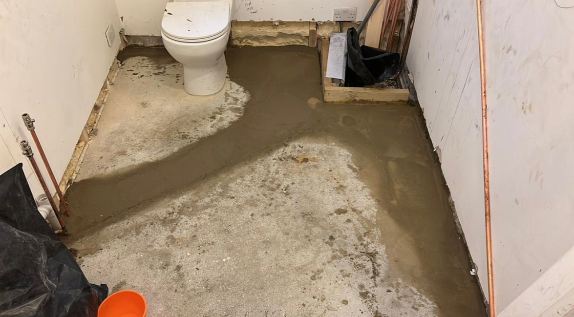 Bathroom renovation in progress showing toilet and copper pipework
