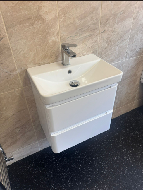 Wall-hung vanity unit with white basin in beige tiled bathroom